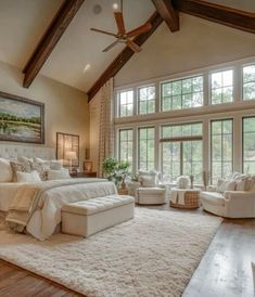 a large bedroom with lots of windows and white furniture in the middle of the room