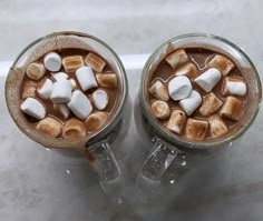 two cups filled with hot chocolate and marshmallows