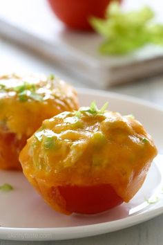 two small stuffed tomatoes on a white plate