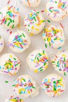 white frosted donuts with sprinkles and colored icing on top