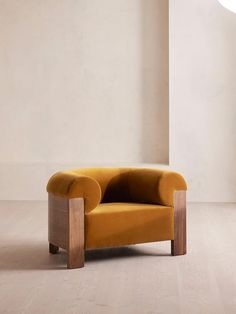 an orange chair sitting on top of a hard wood floor next to a white wall