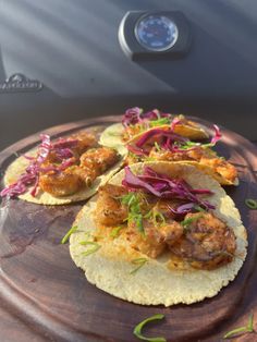 three tacos with meat, onions and red cabbage on a tortilla shell