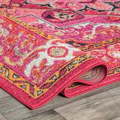 an area rug on the ground with wood flooring and wooden floors in the background