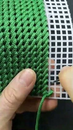 someone is stitching green thread on a piece of fabric