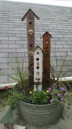 a bird house sitting on top of a metal planter