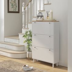 a white cabinet sitting next to a stair case