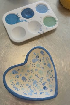 two heart shaped dishes with paint on them