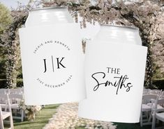 two white can coolers with the initials j and k on them in front of an outdoor ceremony