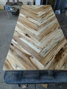 a table made out of wood sitting on top of a piece of metal in a garage