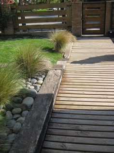 a wooden walkway leading to a grassy area