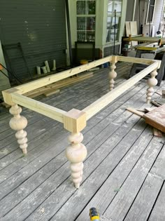 a wooden bed frame sitting on top of a wooden floor next to a bottle of beer