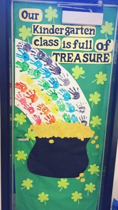 a classroom door decorated with handprints and a pot of gold on the front