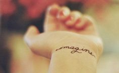 the word imagine written in cursive writing on someone's arm and foot