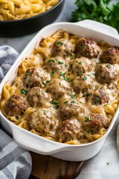 a casserole dish filled with meatballs and noodles