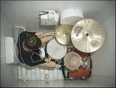 a man is playing drums in the bathroom