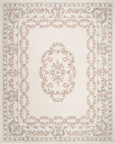 a white rug with pink flowers and scrolls on the center, in an ornate frame