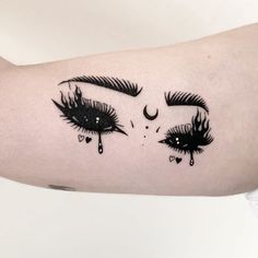 a woman's arm with black and white tattoos on her face, eyes and eyelashes