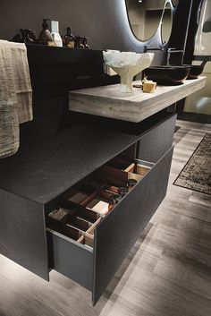 an open drawer in the middle of a bathroom counter next to a sink and mirror