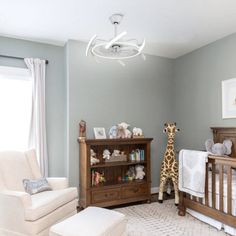 a baby's room with a giraffe in the crib and other furniture