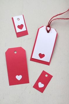 red tags with white hearts on them sitting on a table