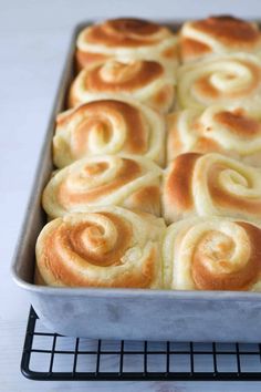 a pan filled with rolls sitting on top of a metal rack next to a white counter