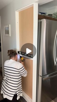 a woman is working on a refrigerator door