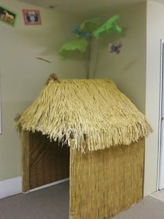 a small hut made out of straw with a thatch roof and door on the outside