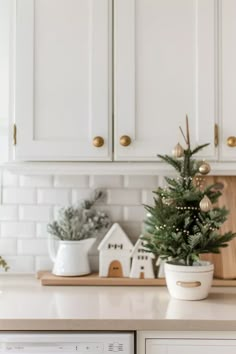 a small christmas tree sitting on top of a counter next to a dishwasher