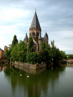 an old castle is sitting on top of a small island in the middle of a lake