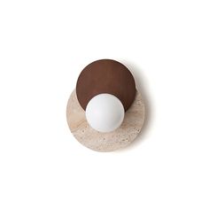 a white and brown object sitting on top of a wooden plate next to a wall