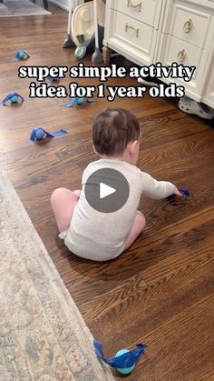 a baby is sitting on the floor playing with some blue plastic birds in front of him