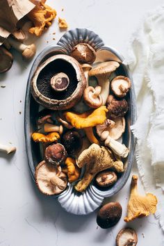 a metal bowl filled with lots of different types of mushrooms