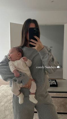 a woman is taking a selfie with her baby in front of the mirror while holding a cell phone