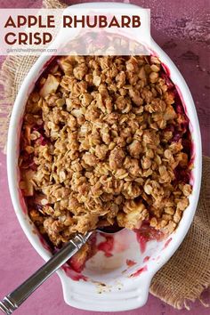 an apple rhubarb crisp in a white bowl with a spoon on the side