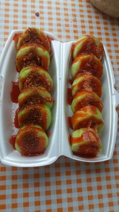 two white trays filled with food sitting on top of a checkered table cloth