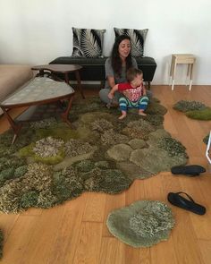 a woman sitting on the floor next to a child