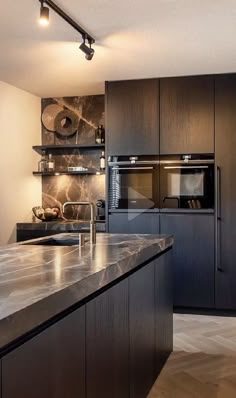 a modern kitchen with marble counter tops and stainless steel appliances, along with dark wood cabinets