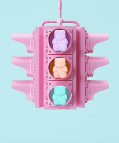 a pink traffic light with three different candies in it