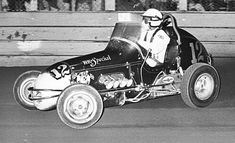 a man riding on the back of a racing car