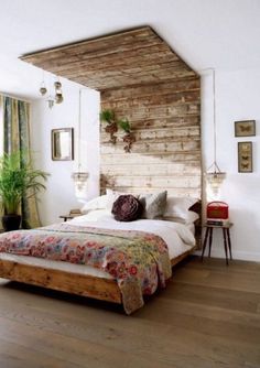 a bed sitting in a bedroom next to a wooden headboard on top of a hard wood floor