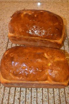 two loafs of bread cooling on a rack