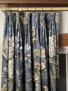 the curtains are hanging in front of a window with flowers and birds printed on them