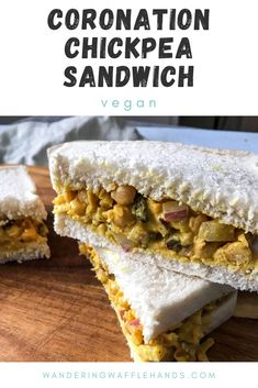 a sandwich cut in half on top of a wooden cutting board with the words, coronation chickpea sandwich vegan