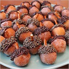 a plate full of donuts with chocolate sprinkles on them and candles in the middle