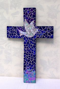 a blue cross with a white dove on it's side and mosaic glass in the middle