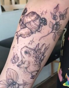 a woman's arm with tattoos on it, including flowers and an animal in the center