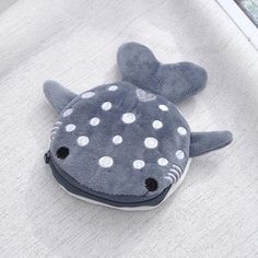 a stuffed animal that is laying down on the ground next to a window with white polka dots