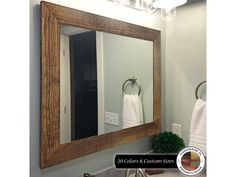 a bathroom mirror sitting above a sink under a light