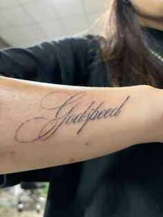 a woman with a tattoo on her arm that reads, unplugged in cursive writing