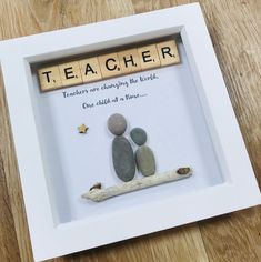 a frame with some rocks in it that says teacher